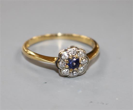 An 18ct and plat, sapphire and diamond cluster set flower head ring, size O.